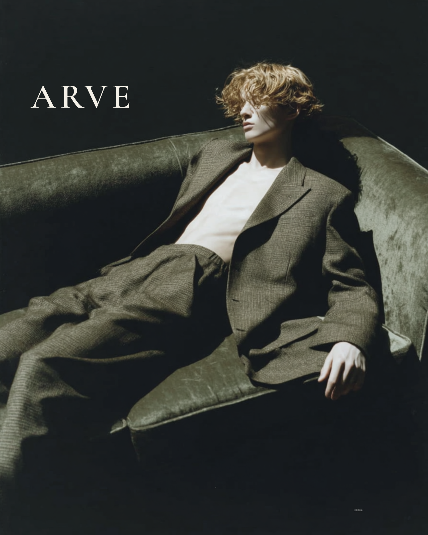 Person wearing a suit sitting on a couch with 'ARVE' branding.